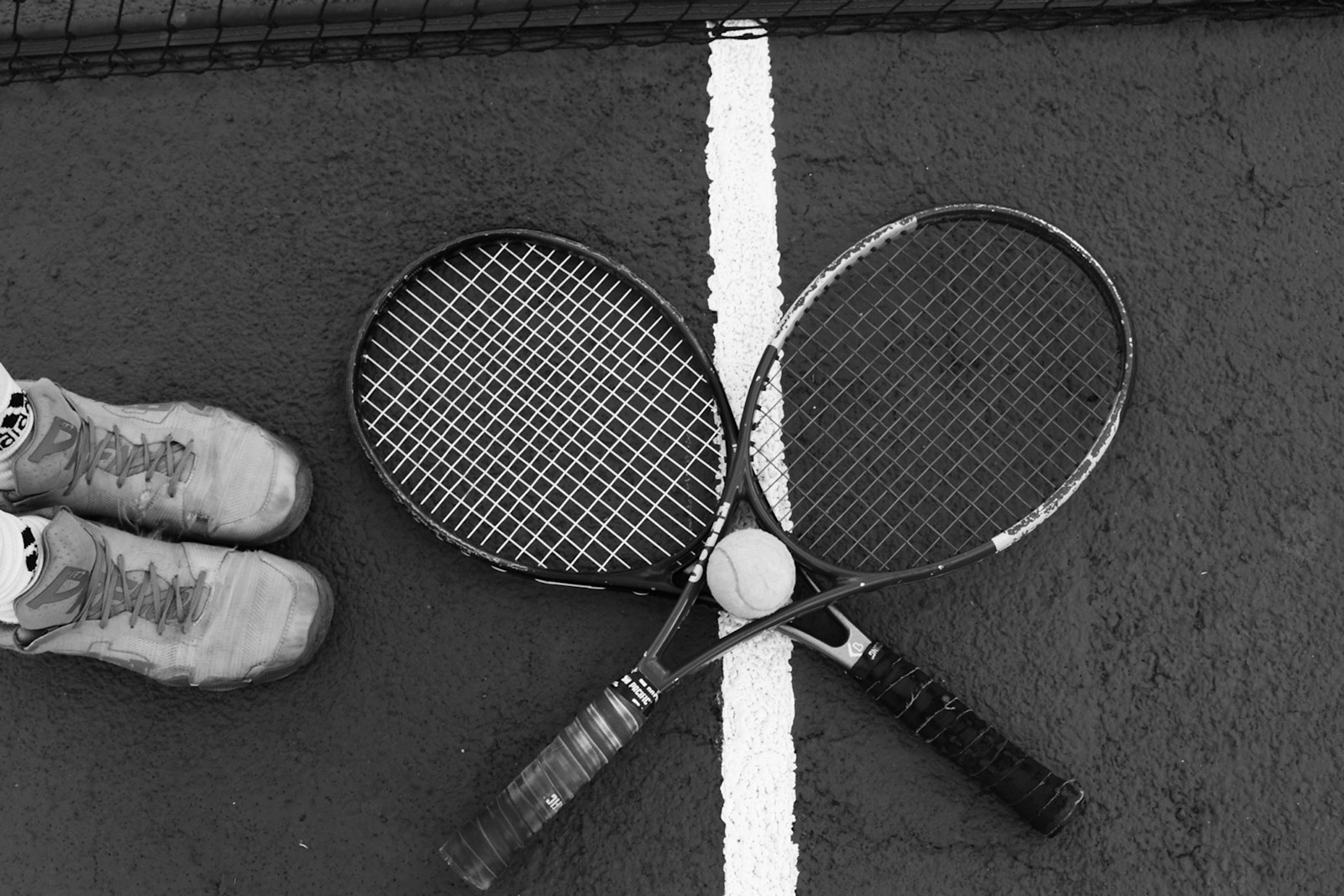 A pair of tennis racquets laying on the ground